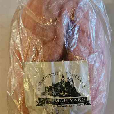 4-oz bag of Ponemah Yarn Carded Wool for Handspinning: The image shows a transparent plastic bag containing a pinkish material, identified as 4 oz of carded wool for handspinning. The label on the bag displays the name "Quinnehticut Woolen Co." and "Ponemah Yarn," along with a drawing of a building or mill. It is marked with a price of $2.00 and provides an address in Norwich, Connecticut, suggesting the place of origin or manufacturing location for the wool packaging. The wool inside the bag appears fluffy and is intended for crafting or spinning purposes, as indicated by the label.