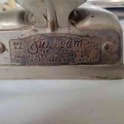The image shows a vintage "Sunbeam" iron base with engraved manufacturer's details, slightly worn.