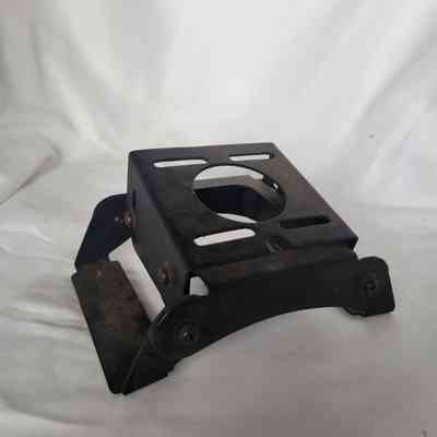 A small, black metal stand with a circular opening on a white surface.