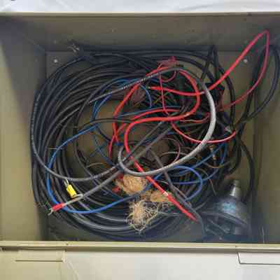 The image shows a metal box filled with tangled electrical wires of various colors and thicknesses.