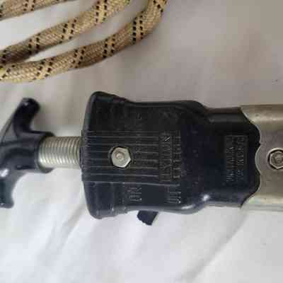 The image shows a black and metal plug connected to a coiled beige cord.