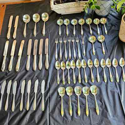 The Community Plate Silverware, Monogrammed with the Letter E: From the top left: Luncheon knives, large soup spoons (table spoon size), bouillon spoons, luncheon knives again, seafood forks, lemon fork, bouillon spoons again, teaspoons, fruit knives / butter knives, ice cream spoons