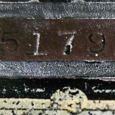 Singer Sewing Machine, Model Number: The image depicts a close-up view of an old, weathered black and silver metal plate displaying the engraved serial number "G5517926," which is slightly worn, suggesting that it may have been part of a vintage machine or equipment; the surrounding area shows signs of wear and tear, with visible scratches and paint peeling, indicating prolonged usage and exposure to the elements, and the background features a textured surface with a mix of green and beige tones, adding to the antique appearance of the entire composition.