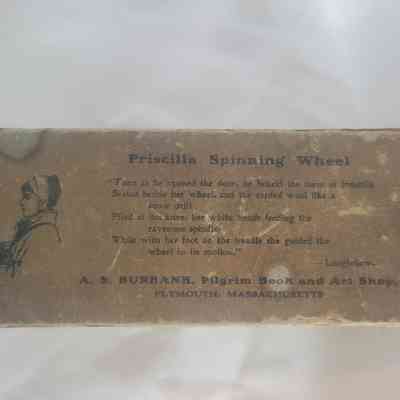 The vintage box lid titled "Priscilla Spinning Wheel" features Longfellow's poetry.