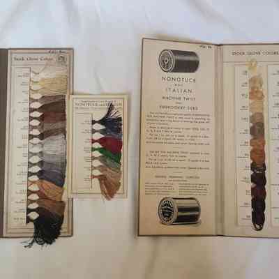 The image shows two booklets displaying various embroidery silk colors on labeled cards.