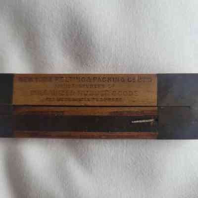 The image shows a vintage wooden ruler with text, "New York Belting & Packing Co Ltd".