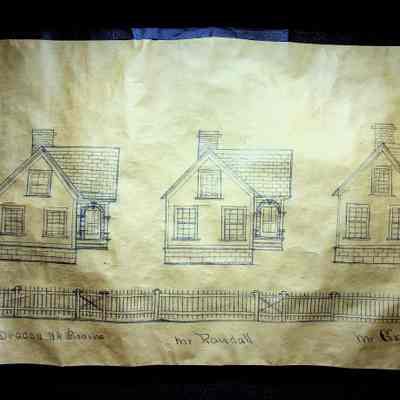 An image from the street view of Baby Lane/Valley Street. Three full houses can be seen from this image from right to left: Deacon NA Starns, Mr. Randall, and Mr. Green.: The three houses seen in this image are all nearly identical. They are L-shaped with front-facing doors off to the right of the house.  There are three windows from the front view one on the second floor/attic and two on the first floor. They have shingled roofs with a chimney in roughly the center of the house possibly towards the back.