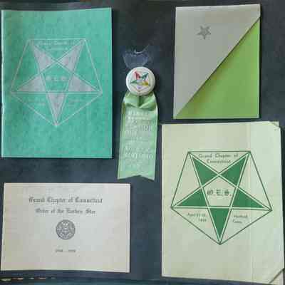 A black scrapbook page with multiple shapes and sizes of ephemera attached.