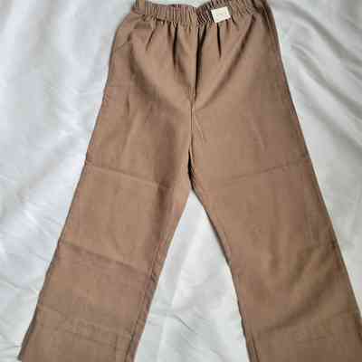 The image shows a pair of brown pants with an elastic waistband lying on a white surface.