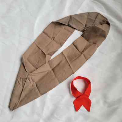 Two pieces of fabric, one brown and one red, are arranged on a smooth white surface