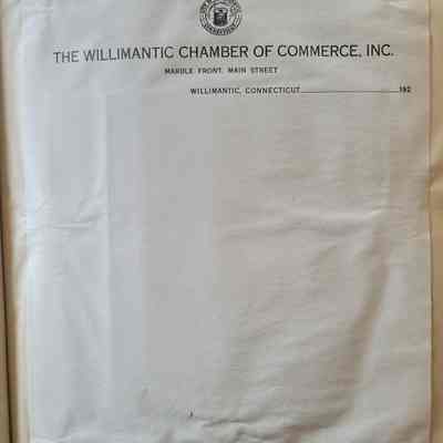 White letterhead with black lettering and a black circular emblem of a spool of thread, on a beige background. The paper is wrinkled around the edges where wet glue was used to adhere it to the background.