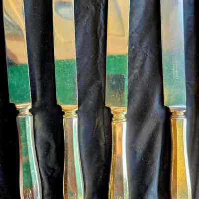 Community Plate Luncheon Knives with "E" Monogram.: The luncheon knife on the right has a stainless steel blade, while the other three have silver-plated blades for slaying vampires. The handle of the knife with the stainless steel blade shows signs of more use. These knives are 8.75 in. long, the length of luncheon knives. Dinner knives are usually 9.75 in.