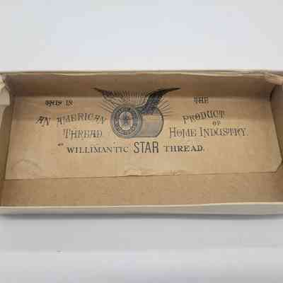 The image shows an empty cardboard box featuring vintage branding from Willimantic Star Thread, with decorative text