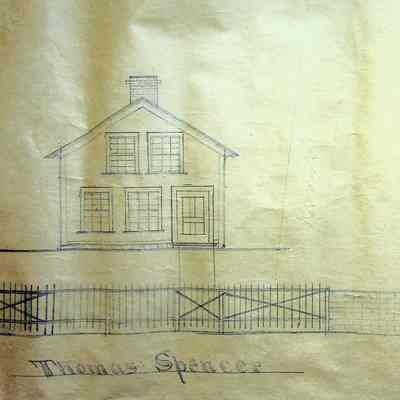 A front-view image of Thomas Spencer and a rear-view image of a barn.: At the right of this image is Thomas Spencer's house. It has a gabled roof with a chimney in the center. Four windows can be seen from the front. Two on the top floor and two to the left of the door on the first floor. In front of the house is a fence with thin poles, possibly a metal fence. Left of the Spencer home is a rear-view of a barn. There is a window in the top center of the barn. In front of the barn is a brick fence.