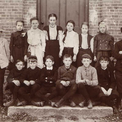Olga Victoria Pherson (standing, second from left): notation on back: "Standing [l to r] - Forest West, Olga Pherson, Bernice Bills, Sterna Raymond, Ethel Murphy, Neva Sloan, Marie Duval and Charles Randall; 1st  row sitting [l to r] - Frank Pettengill, Malcolm Clark, Benjamin Mac Namee, Roy Carpenter, Lawrence Wilson, Oscar Nelson; standing"