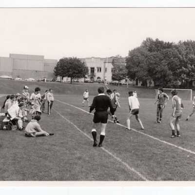 Men's soccer game on Finnesey Field with Field House/Sports Complex in background.