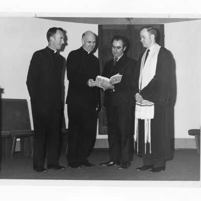 Rabbi of Beth David Reform Congregation present books on Judaism to Terrence Toland, S.J. and Donald Clifford, S.J., February 1970.