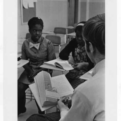 Student tutoring children at Rhoads Public School (?) as part of community service/outreach project. (Peace and Human Development program?)