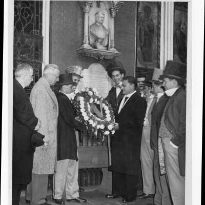 Several students dressed in nineteenth century garb laying wreath at Father Barbelin's shrine at Old Saint Joseph's Church, Willing's Alley, during centennial anniversary celebration.