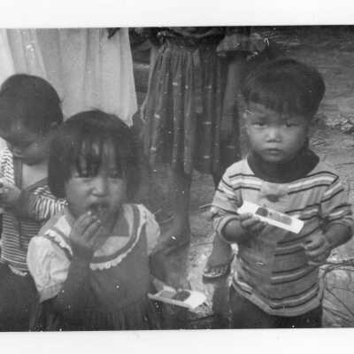 Three Vietnamese children eating, Vietnam Orphanage project.
