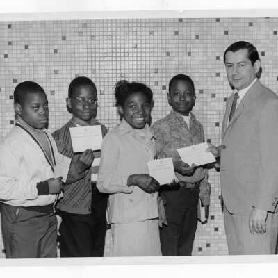Children from Rhoads Public School receiving certificates/awards as part of student community service/outreach tutoring project.