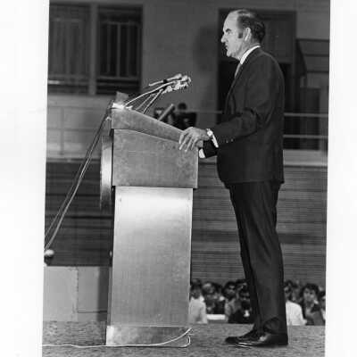 Senator George McGovern delivering speech from podium in Field House, October 2, 1969.