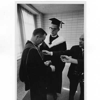 Inauguration of President Terrence Toland, S.J., November 14, 1968. Before ceremony, Toland and Jerome Coll, S.J. practice the investiture for picture-taking session.