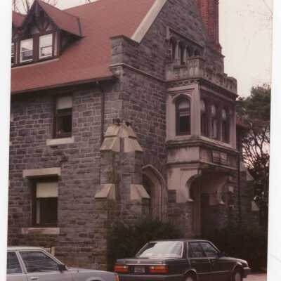 Side view of Wolfington Center (formerly Gest Estate, Neumann Hall) with parked cars.