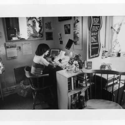 Student studying at desk in dormitory room.