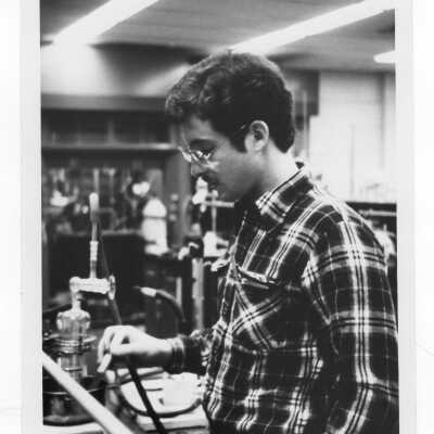 Male student conducting experiment in science laboratory.