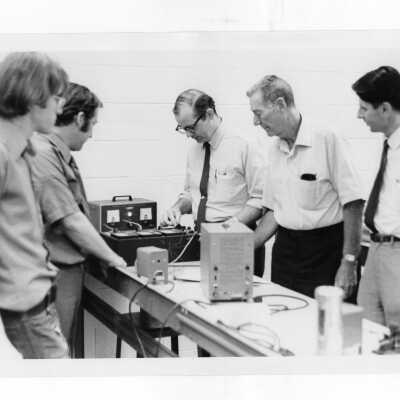 Howard J. Heim, S.J., professors and students working in science laboratory.