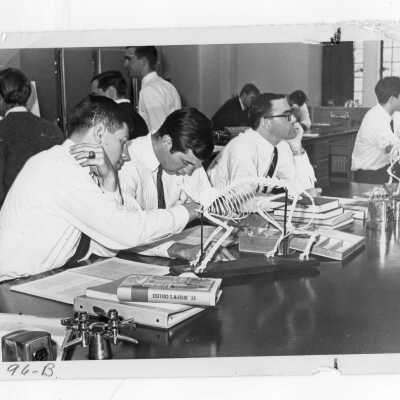Students wearing shirt and ties in biology laboratory.