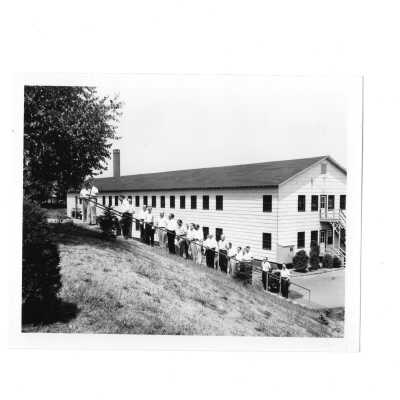 Summer alumni spiritual retreat on SJC campus, c. 1958, with view of attendees walking up steps behind Cardboard College.