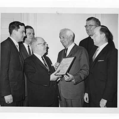 Dr. William N. Parkinson showing Shaffrey award certificate to Dr. DeSilvera, Dr. McKenna, Dr. Scarano, William F. Maloney, S.J., Dr. Meehan, April 12, 1964.