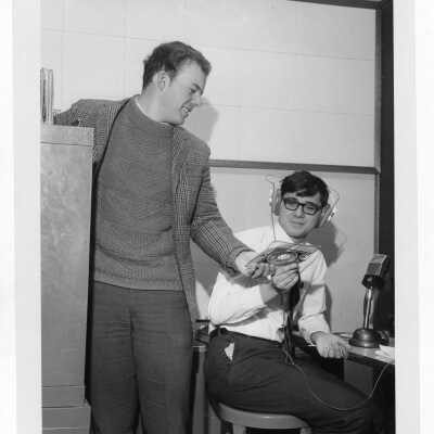 Two students in Radio Club (Station WSJR?) deciding which forty-five rpm record to play.