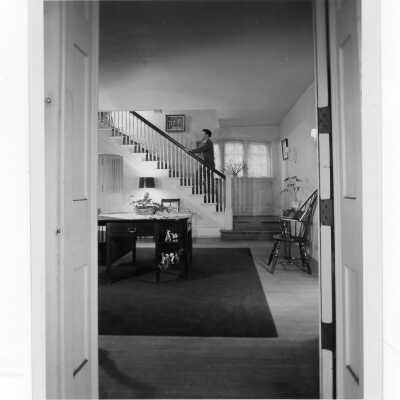 Interior view of hallway in Greaton Hall with student walking up the stairs.