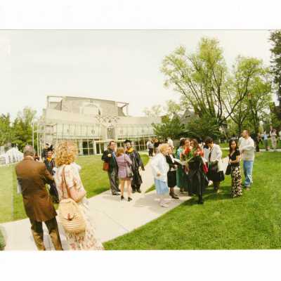 Graduated students with family and friends in front of chapel after 1999 graduation/commencement.
