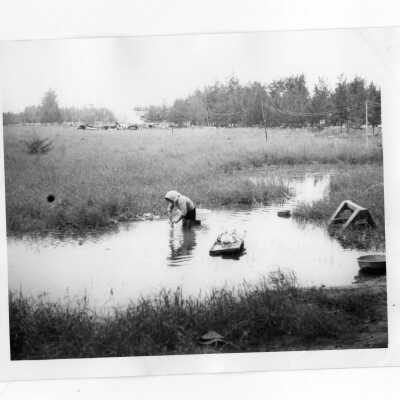 Vietnamese woman washing clothes by hand in river near Vietnam Orphanage.