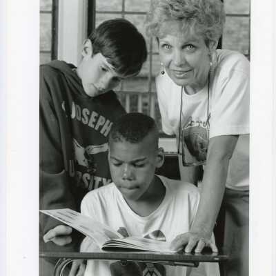 Mary DeKonty Applegate (Department of Education and Health Services) tutoring two students.