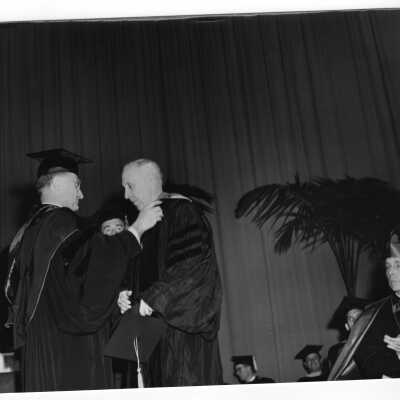 Edward G. Jacklin, S.J. bestowing honorary degree on Francis J. Hardart during 1954 graduation/commencement ceremony with Bishop John F. O'Hara looking on.