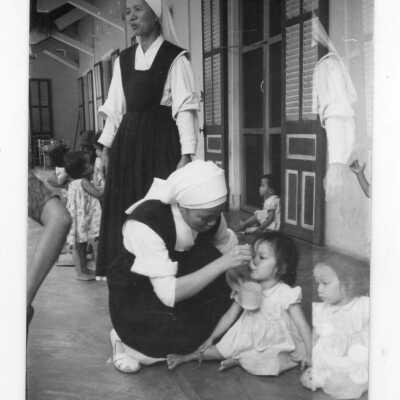 Two Vietnamese nuns feeding Vietnamese children, Vietnam Orphanage children.