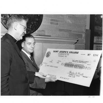 Alumnus from class of 1938--Charles Krull-- presenting William F. Maloney, S.J. with check for $5,357.00 during twenty-fifth reunion, June 6, 1964