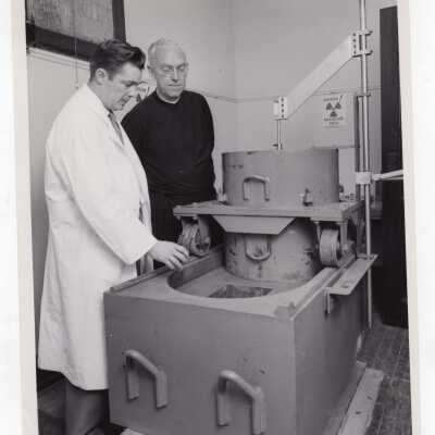 Chemistry professor, Joseph Feighan, showing new radio isotope machine to SJC president, J. Joseph Bluett, S.J., in science laboratory, May 1959.