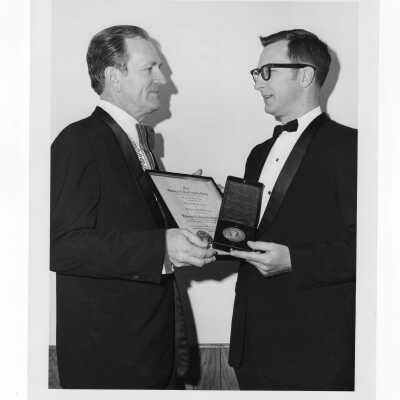 Shaffrey award recipient, Dr. Edward J. Kowalewski, showing medal and certificate to another individual, March 27, 1971.