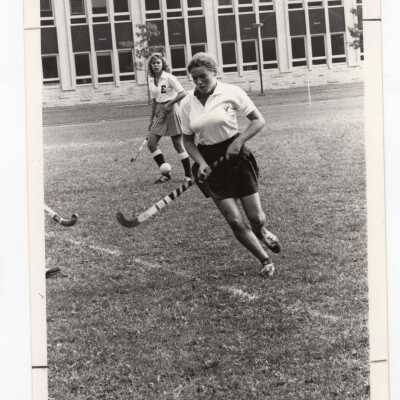 Women's field hockey match on Finnesey Field with Post Hall (formerly Villiger) in background.