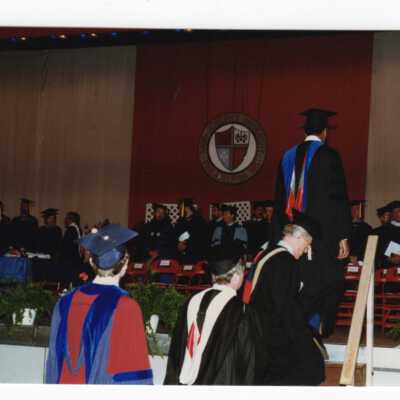 Faculty members, including Anthony Joes and David White (?) processing to stage during 1990 graduation/commencement.