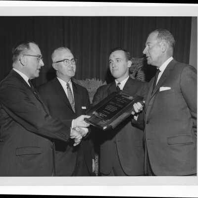 Joseph F. McKinney receiving Hogan Alumni Award with John Clark, Mayor James Tate, and William F. Kelly watching, February 27, 1963.