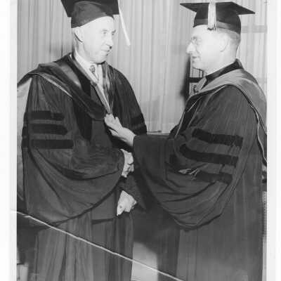 Francis J. Hardart (class 1905 ) receives Golden Hawk medal from Edward G. Jacklin, S.J., during 1955 graduation/commencement.