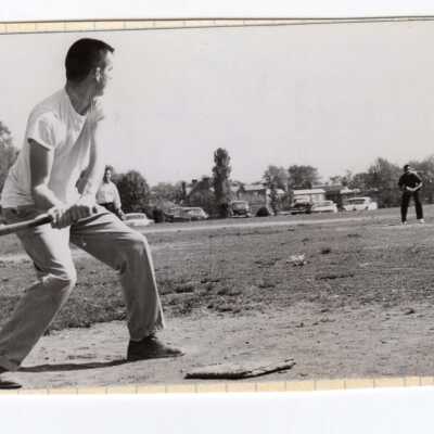 Students playing pick-up baseball with veterans barracks in background?