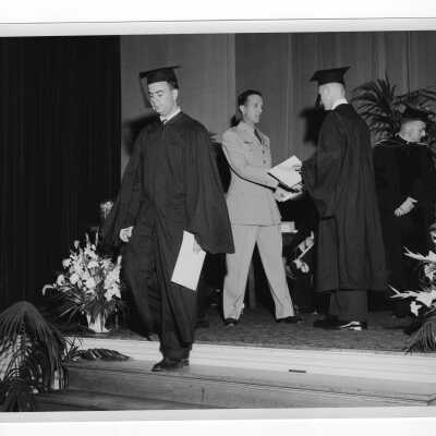 Tropaia exercises during 1955 graduation/commencement with students receiving award from Colonel Ray Gehrig and Edward G. Jacklin, S.J. in background.